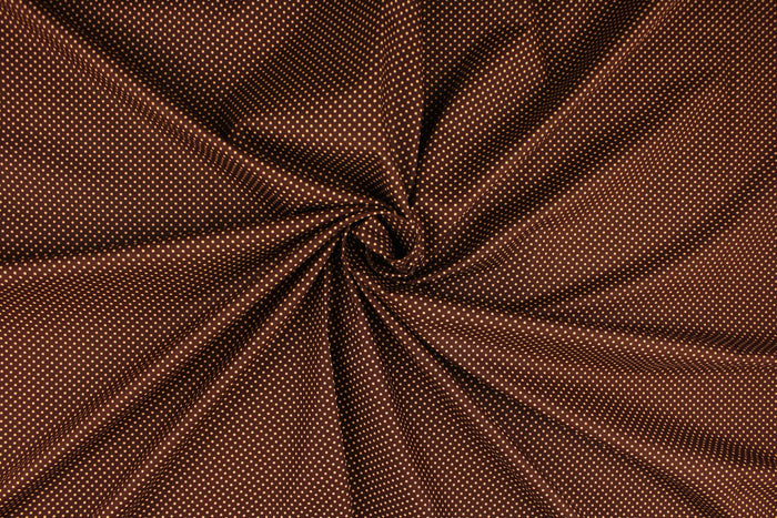 This fabric features small orange polka dots on a brown background.  The versatile lightweight fabric is soft and easy to sew.  It would be great for quilting, crafting and sewing projects.