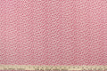 This fabric features a tiny floral design in red set against a white background.