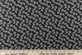 This fabric features a whimsical floral design in white on a black background.
