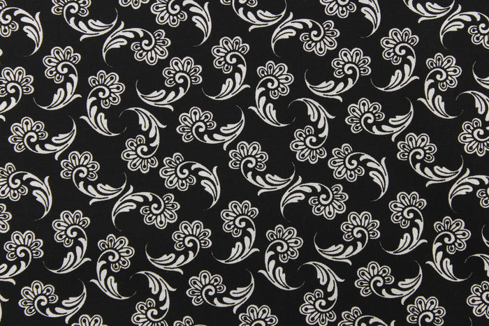 This fabric features a whimsical floral design in white on a black background.