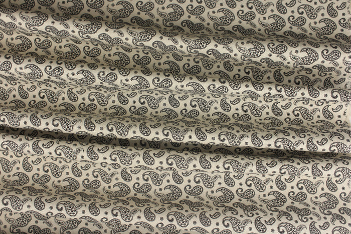 A fun paisley design in basic colors of  black set against a cream background.