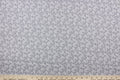This fabric features a paisley design in white set against a gray background.