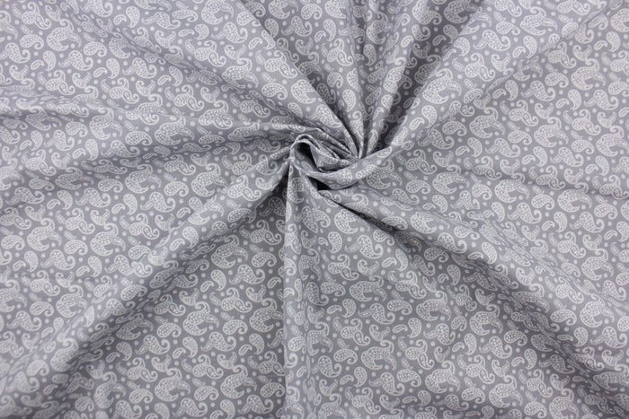 This fabric features a paisley design in white set against a gray background.