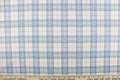 This quilting print features a plaid design in blue, white, green, and a orangey yellow.