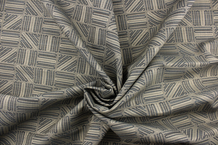 This high end upholstery weight fabric features a geometric design in blue and beige on a metal gray background.  It is suited for uses that requires a more durable fabric.  The reinforced backing makes it great for upholstery projects including sofas, chairs, dining chairs, pillows, handbags and craft projects.  It is soft and pliable and would make a great accent to any room.