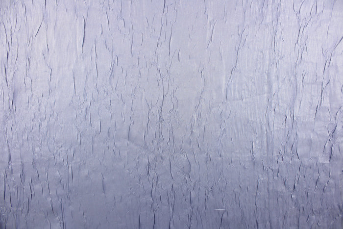 This taffeta fabric features a crinkle in iridescent silver blue color.