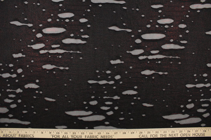 This stretch lycra blend fabric in black with undertones of red.