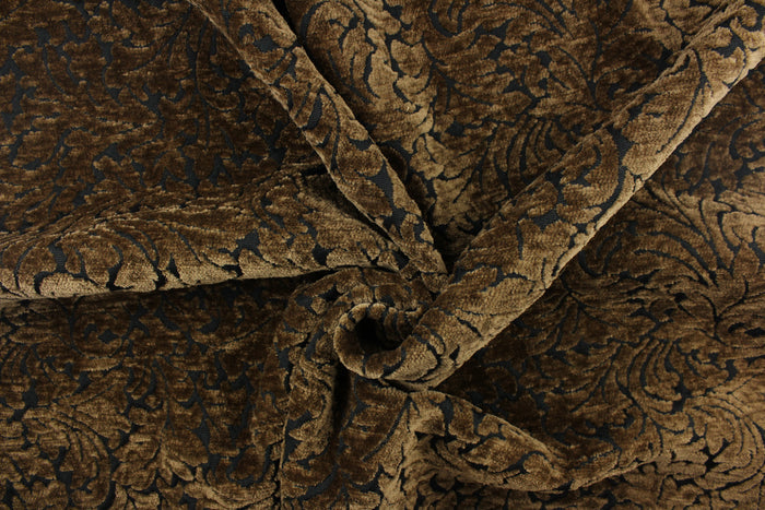 This hard wearing, textured chenille fabric features a unique leaf design in bronze on a black background.