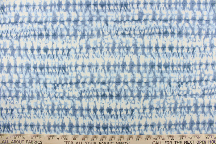 This fabric features an abstract design in varying shades of blue and white.