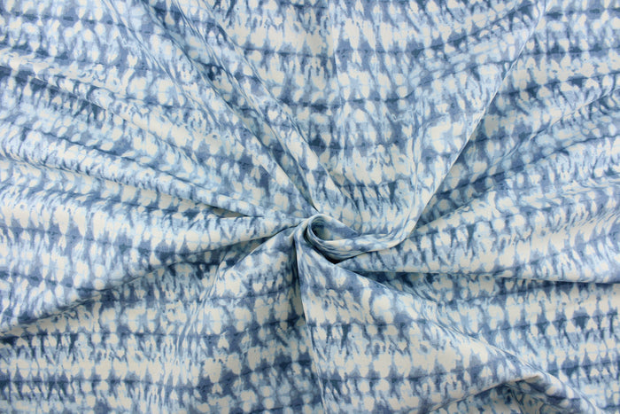 This fabric features an abstract design in varying shades of blue and white.