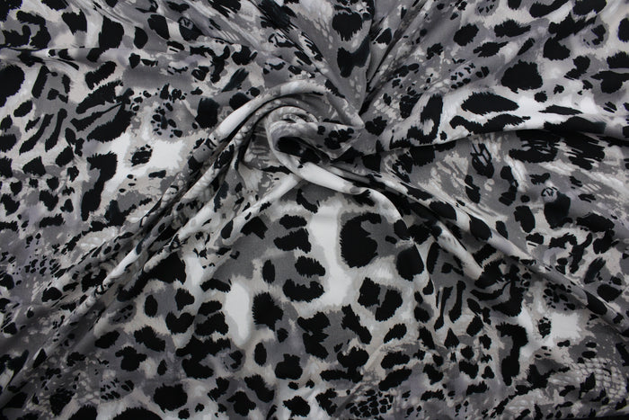 Featuring an eye-catching ocelot print in black, white, shades of gray, and light beige, the unique pattern stands out while the classic colors blend in for a sophisticated and timeless look.  The high-quality cotton material ensures lasting durability and softness.  It would be great for apparel, quilting, crafting and sewing projects.