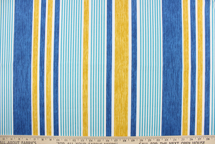 This outdoor fabric features a stripe design in blue, white, golden tan, and aqua.