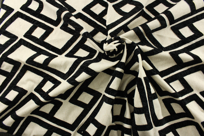 Featuring a stunning embroidered chenille fabric, P/Kaufmann© Accolade in Onyx adds a touch of elegance to any space. Its geometric design in black against a natural background brings a modern touch, while its high durability, with 51,000 double rubs, makes it a perfect choice for upholstery, drapery, and bedding.