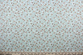 Cicely features an intricate floral pattern in shades of brown, tan, white, and black, set against a light green background.  The high-quality cotton material ensures lasting durability and softness.  It would be great for apparel, quilting, crafting and sewing projects.
