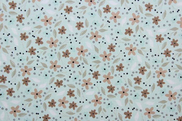 Cicely features an intricate floral pattern in shades of brown, tan, white, and black, set against a light green background.  The high-quality cotton material ensures lasting durability and softness.  It would be great for apparel, quilting, crafting and sewing projects.