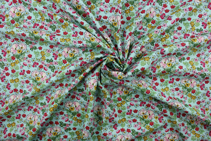 Flower Girl features a bright and cheerful floral print in a range of colors: mustard yellow, green, red, pink, white, and black on a blue background.  The high-quality cotton material ensures lasting durability and softness, making it perfect for your next quilting or stitching project.  The versatile lightweight fabric is soft and easy to sew.  It would be great for apparel, quilting, crafting and sewing projects.