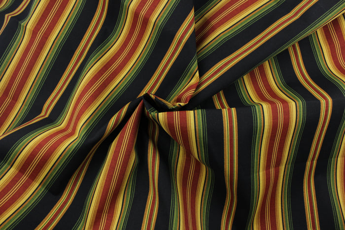 This Richloom© Lyndhurst in Raven multipurpose outdoor fabric adds a unique style to any space, featuring stripes of green, black, yellow, brick red, and goldenrod.  Durable and long-lasting, it is rated for 10,000 double rubs.  Can withstand up to 500 hours of direct sunlight, it is also water and stain resistant.  Perfect for patio, deck and poolside.  It can be used for several different statement projects including cushions, upholstery projects and decorative pillows.