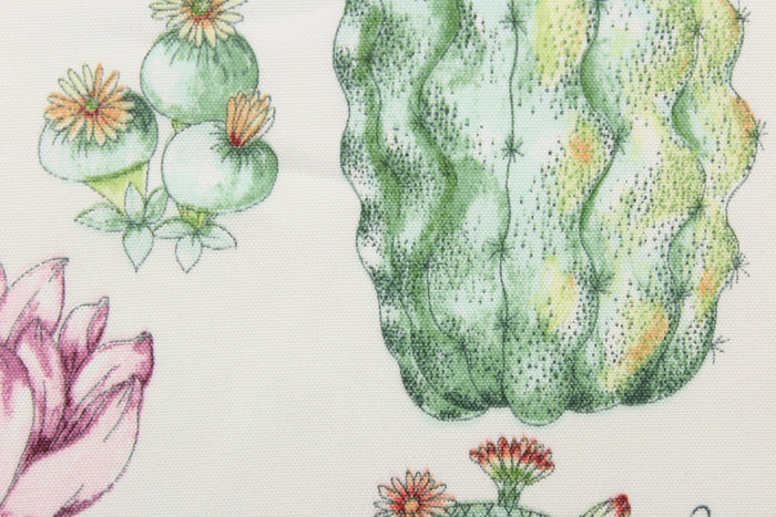 This outdoor fabric features a design of different  cactus in green, orange, purple, and peach with hints golden yellow against white.