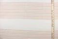 This sheer fabric features a stripe design in orange, brown, red, and golden yellow  against white.