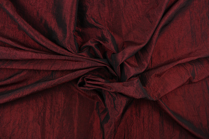 This taffeta fabric features a crinkle in iridescent deep red.