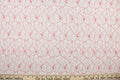 This lace features a woven floral design in white with red outline.