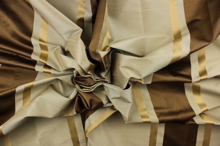 This stunning yarn dyed fabric features a  striped pattern in rich brown tones, gold and taupe.