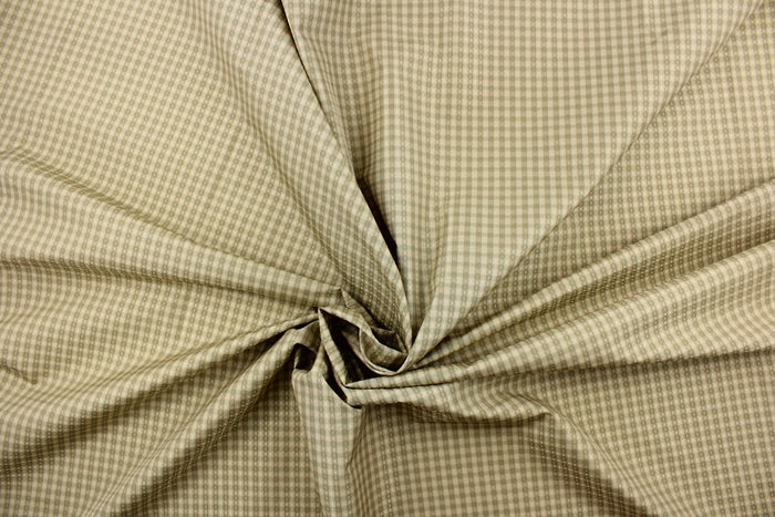 This yarn dye stripe fabric features a small plaid or checkered design in light khaki and pale green.